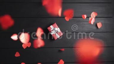 许多红心落在桌子上，桌子上放着一个带礼物的盒子。